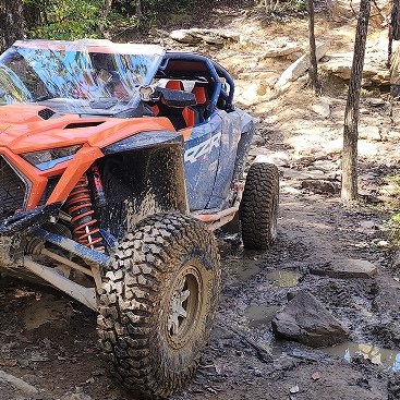 Off-road side-by-side on a muddy forest trail
