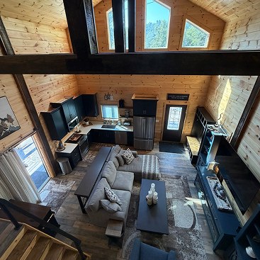 Open-plan cabin living room and kitchen from the loft
